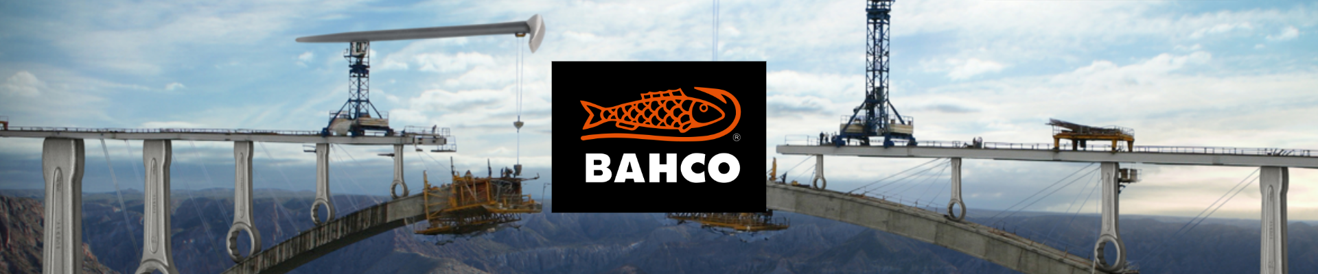 Rakenteilla oleva silta korkealla vuoristomaisemassa, jossa on rakennusnostureita ja työkoneita. Kuvan keskellä on musta Bahco-logo.