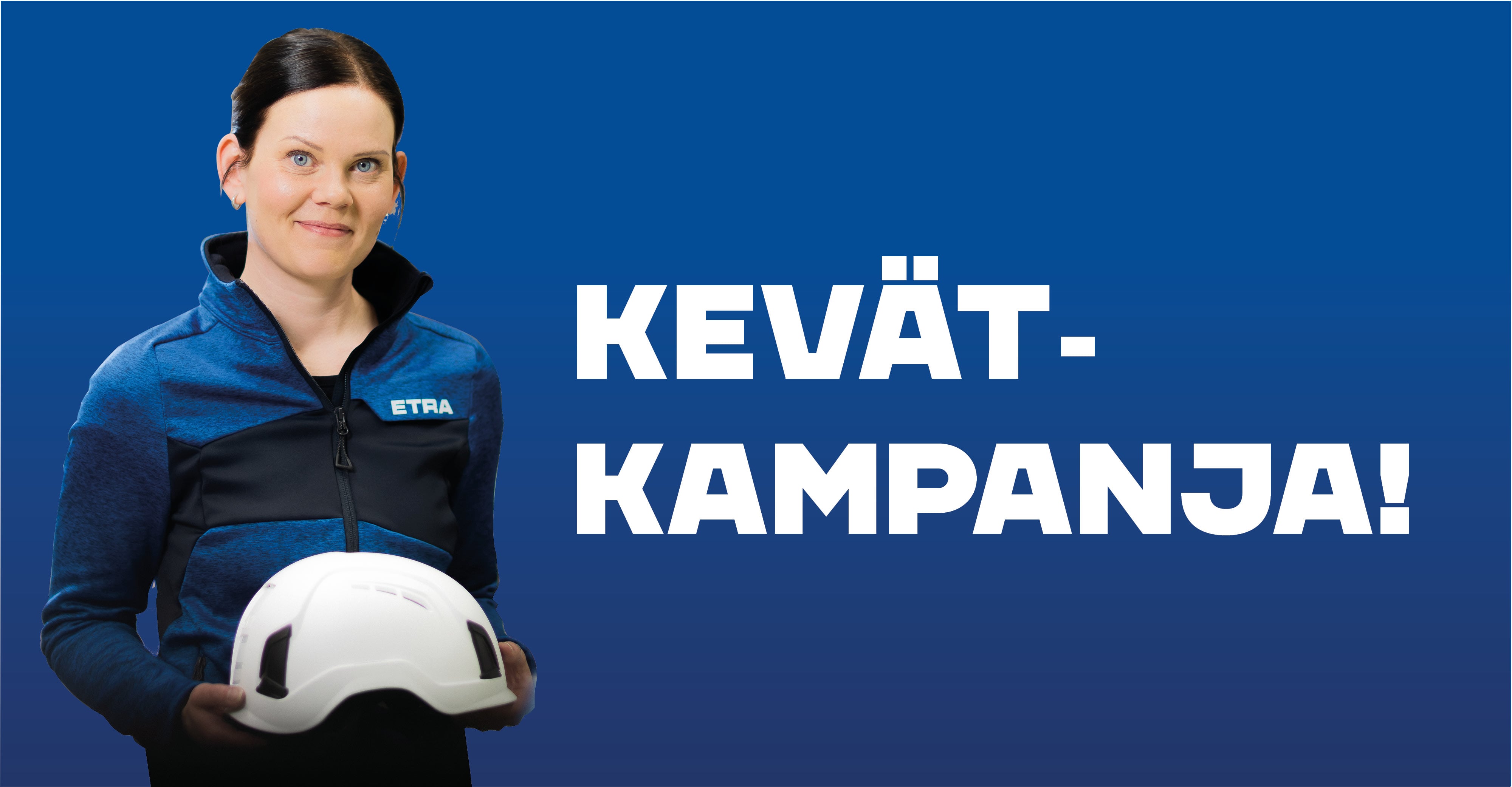 Mainoskuva, jossa nainen hymyilee sinist&auml; taustaa vasten pit&auml;en k&auml;siss&auml;&auml;n valkoista suojakyp&auml;r&auml;&auml;. H&auml;nell&auml; on p&auml;&auml;ll&auml;&auml;n sinimusta Etra-logolla varustettu takki. Kuvan oikeassa reunassa on valkoinen teksti "KEV&Auml;T-KAMPANJA!"