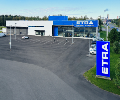 Etras butik med en rymlig gårdsplan, i förgrunden en blåvit ETRA-skylt.