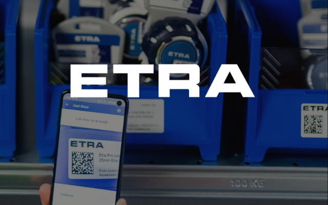 Sinisissä muovilaatikoissa on ETRA-merkkisiä tuotteita hyllyllä. Etualalla käsi pitelee älypuhelinta, jonka näytöllä on ETRA-sovellus ja QR-koodi.