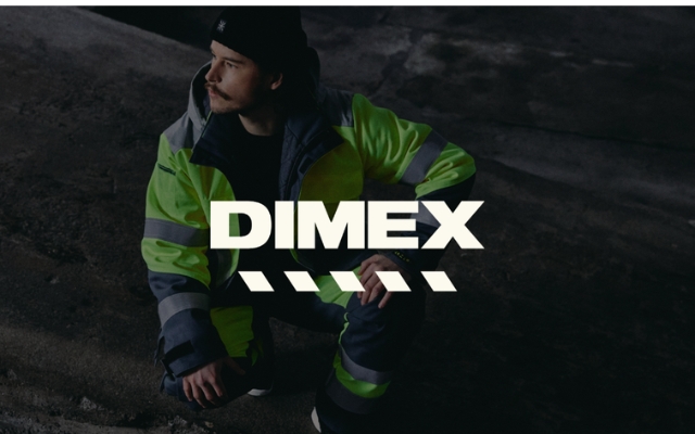 Henkilö istuu kyykyssä hämärässä teollisuusympäristössä pukeutuneena kirkkaan keltaiseen ja harmaaseen heijastavaan työasuun. Kuvan keskellä on valkoinen DIMEX-logo.